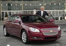 General Motors Vice Chairman Bob Lutz stands with the 2008 North American Car of the Year, the Chevrolet Malibu.